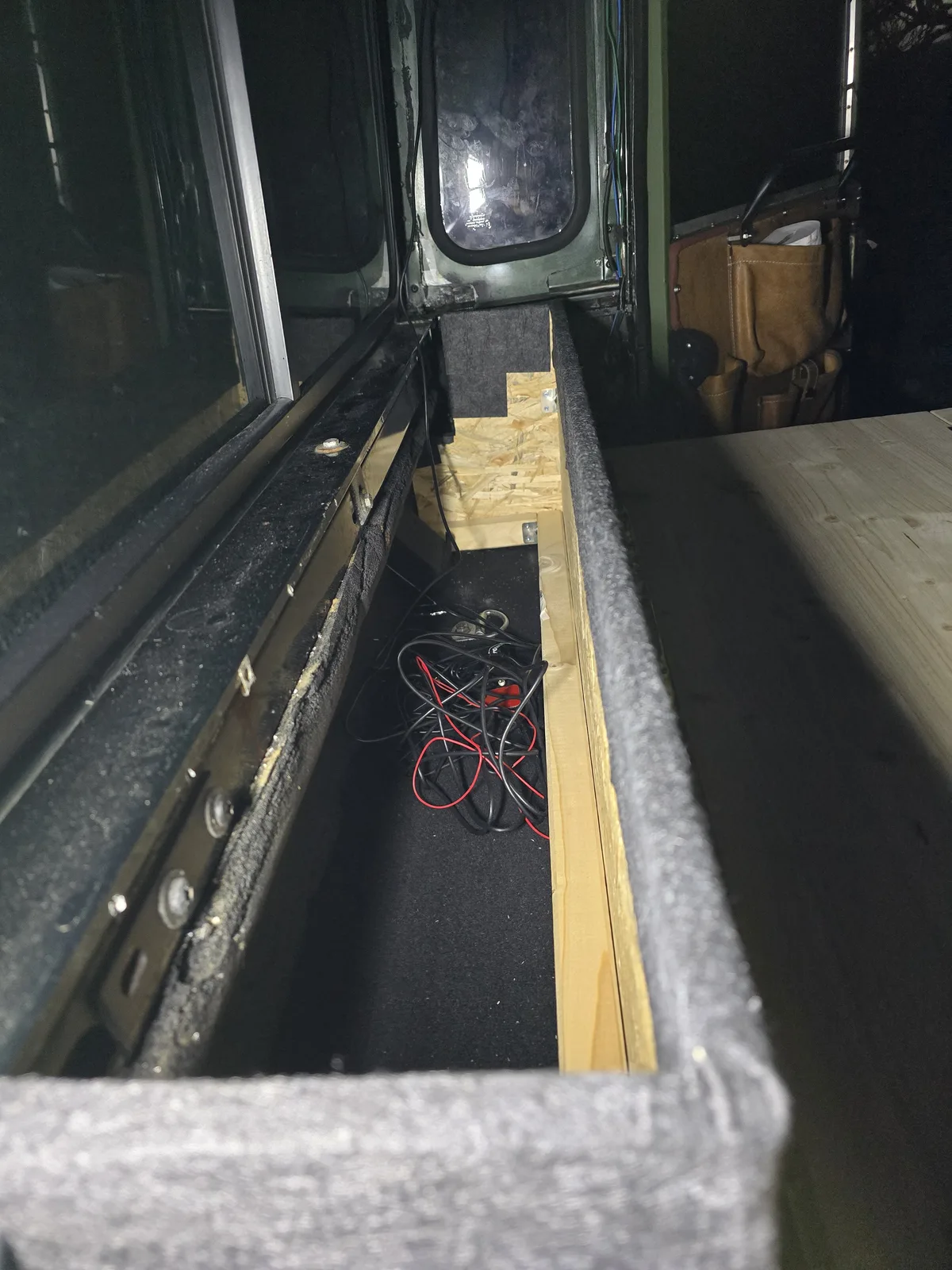 Frühe Ausbauphase mit offenem Stauraum und sichtbaren Kabeln im Defender